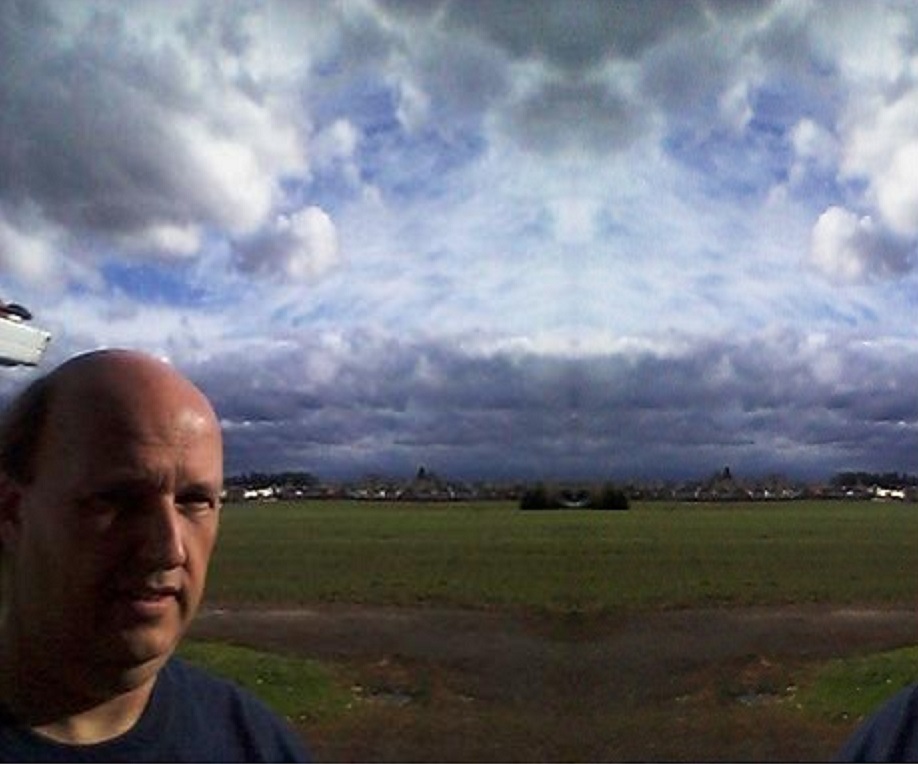 Ron in field with beautiful clouds.